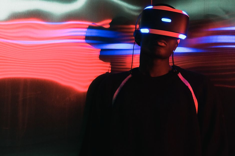Osoba s VR naočalama okružena neonskim svjetlima
